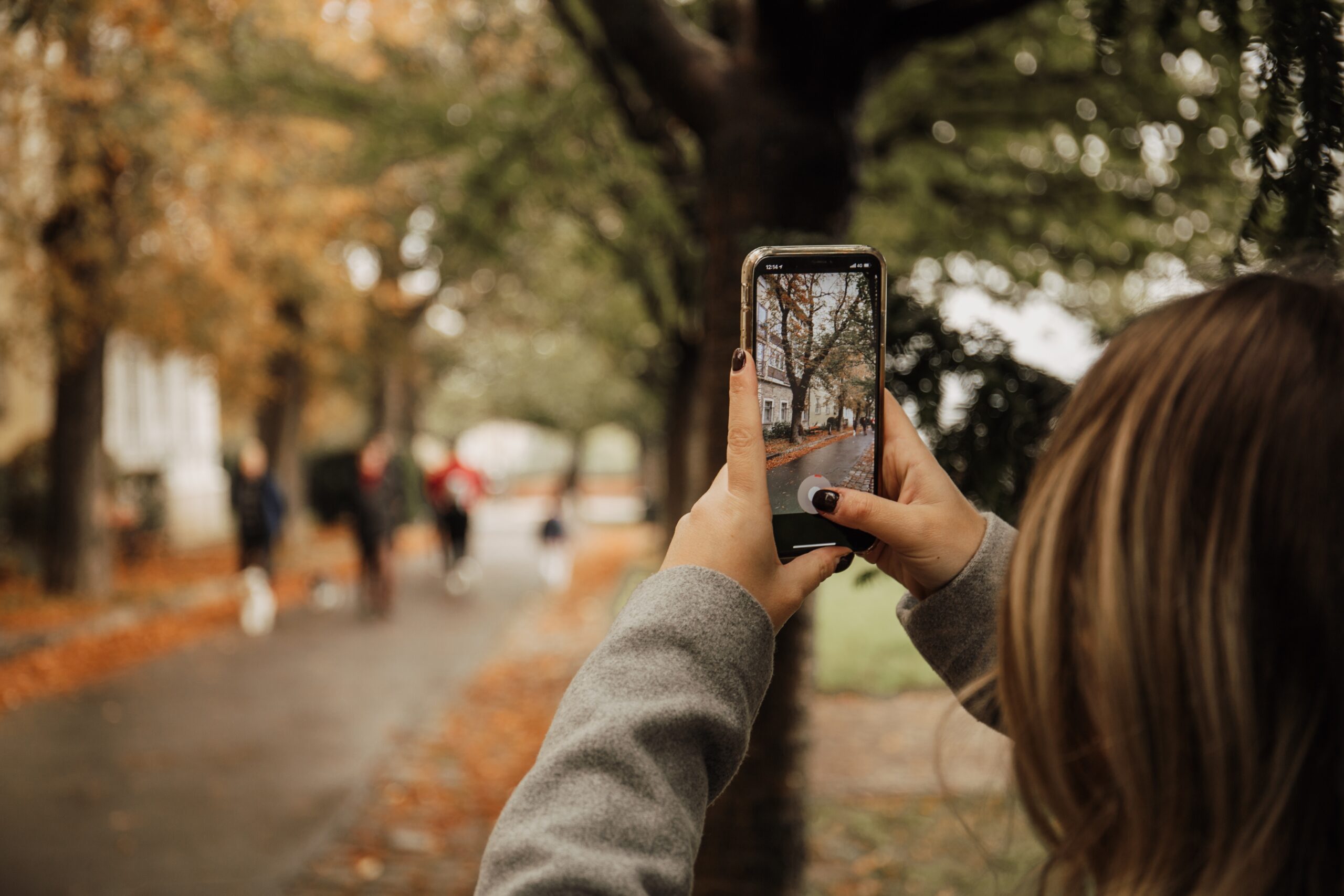 Close up of a girl taking a picture with an iPhone